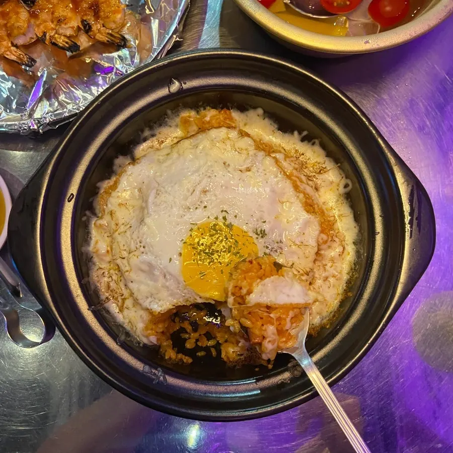 Ttukbaegi kimchi fried rice topped with egg and cheese
