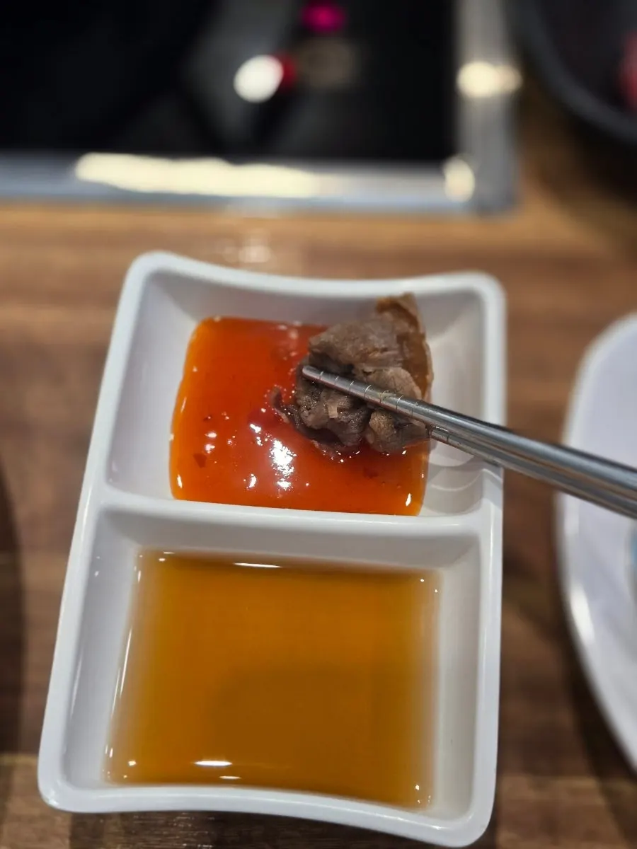 익힌 채소와 소고기를 소스에 곁들인 한 입