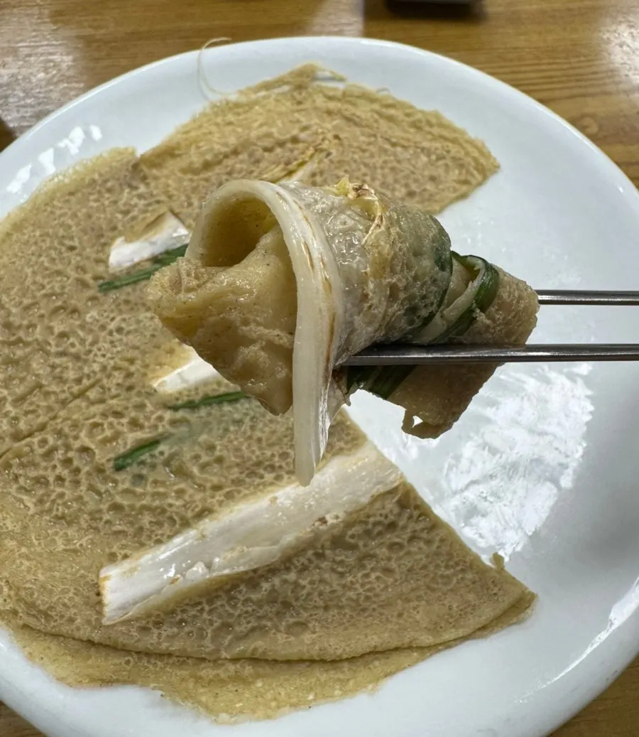 Buckwheat pancake rolled up and dipped in soy sauce