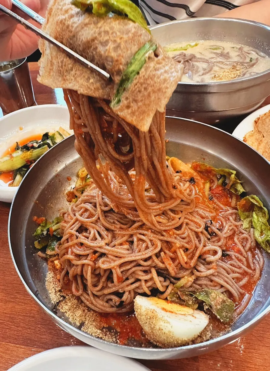 젓가락으로 들어올린 두꺼운 칼국수 면발