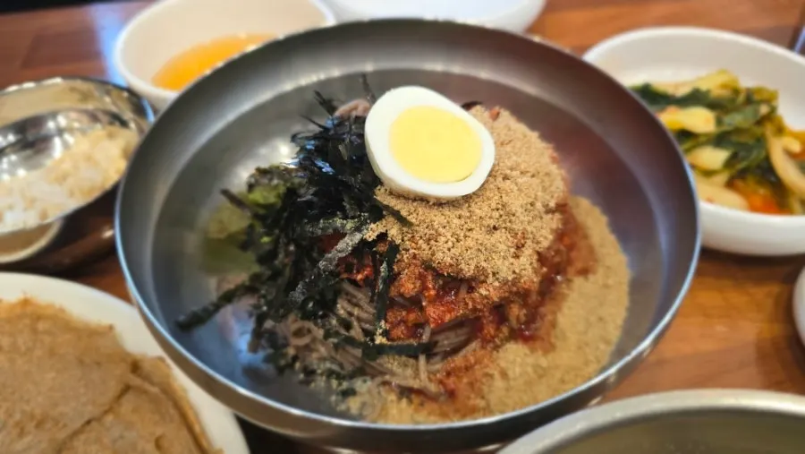 Bibim makguksu topped generously with sesame seeds