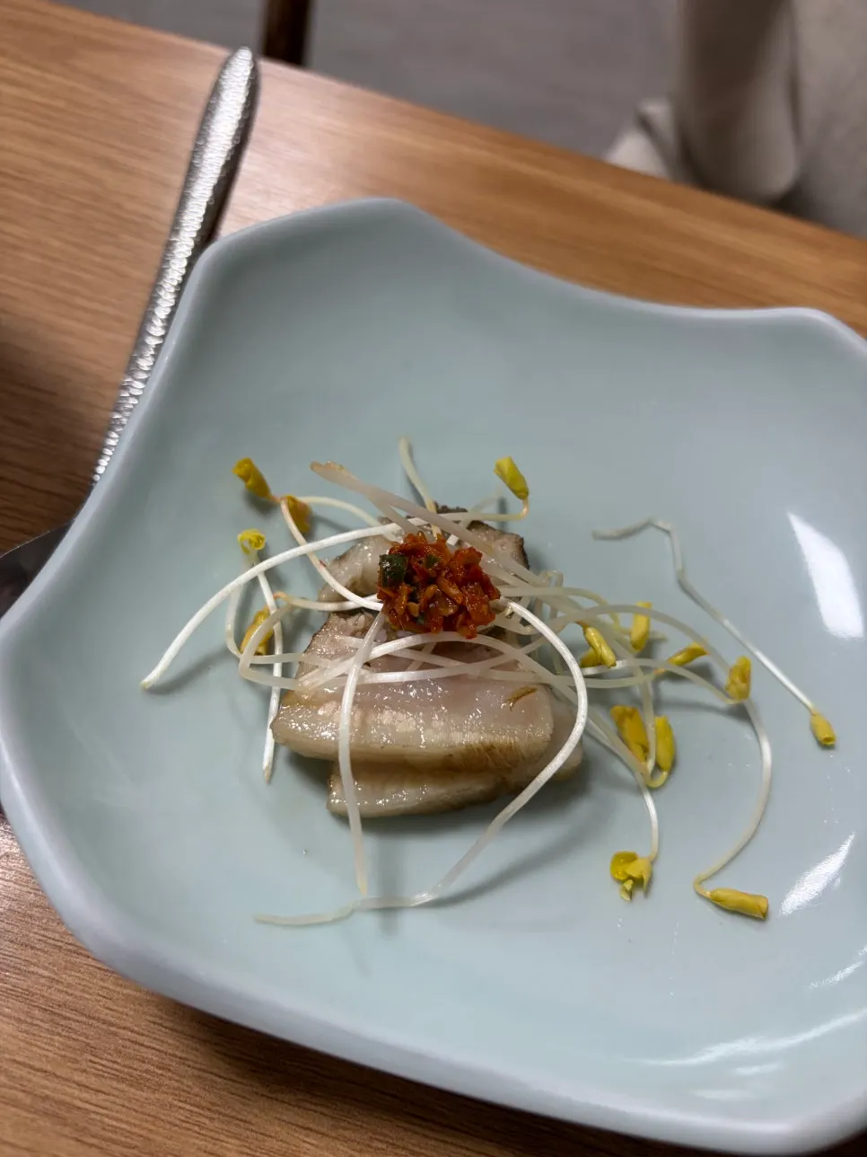 수육 한 점에 메밀싹을 올린 모습