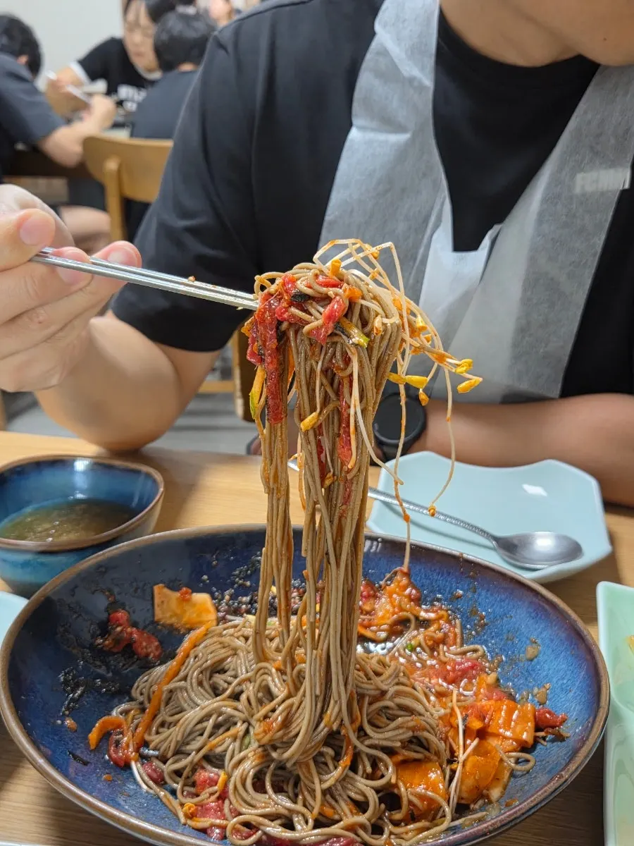 A bite-sized portion of yukhoe bibim makguksu