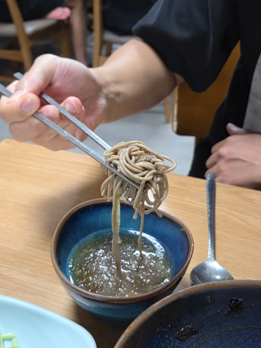 Dipping the extra noodles into the broth