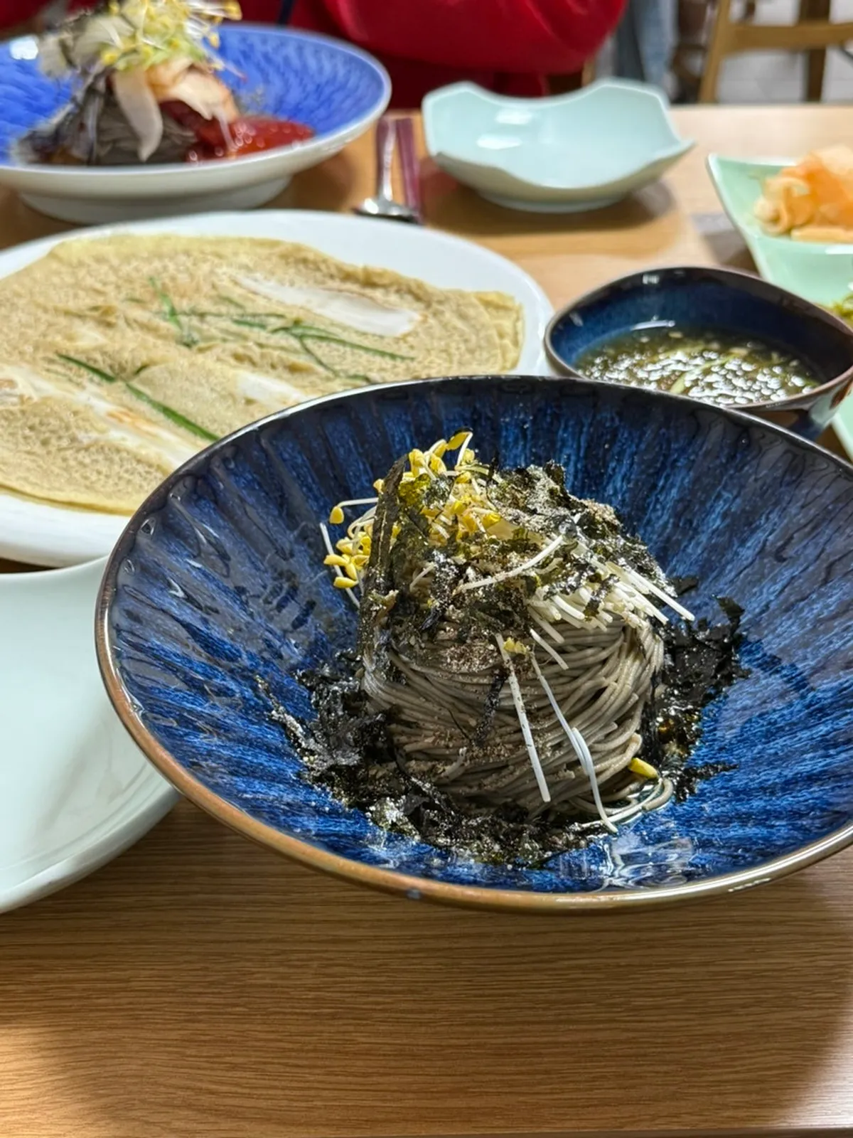 Lunch spread of Migayeon noodles, bibim noodles, and buckwheat pancake