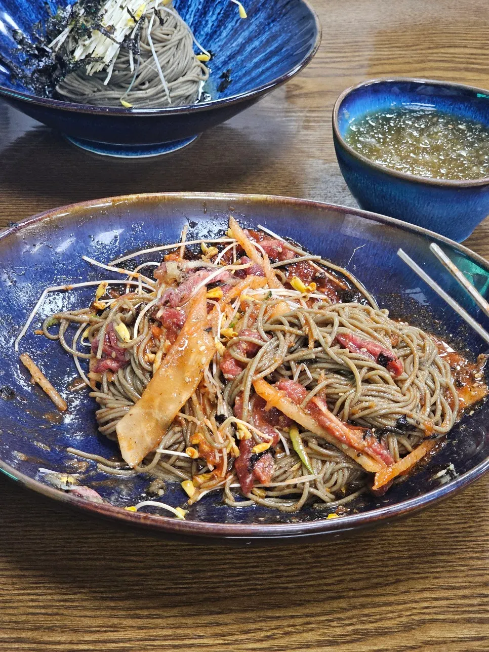 젓가락으로 들어올린 육회비빔국수