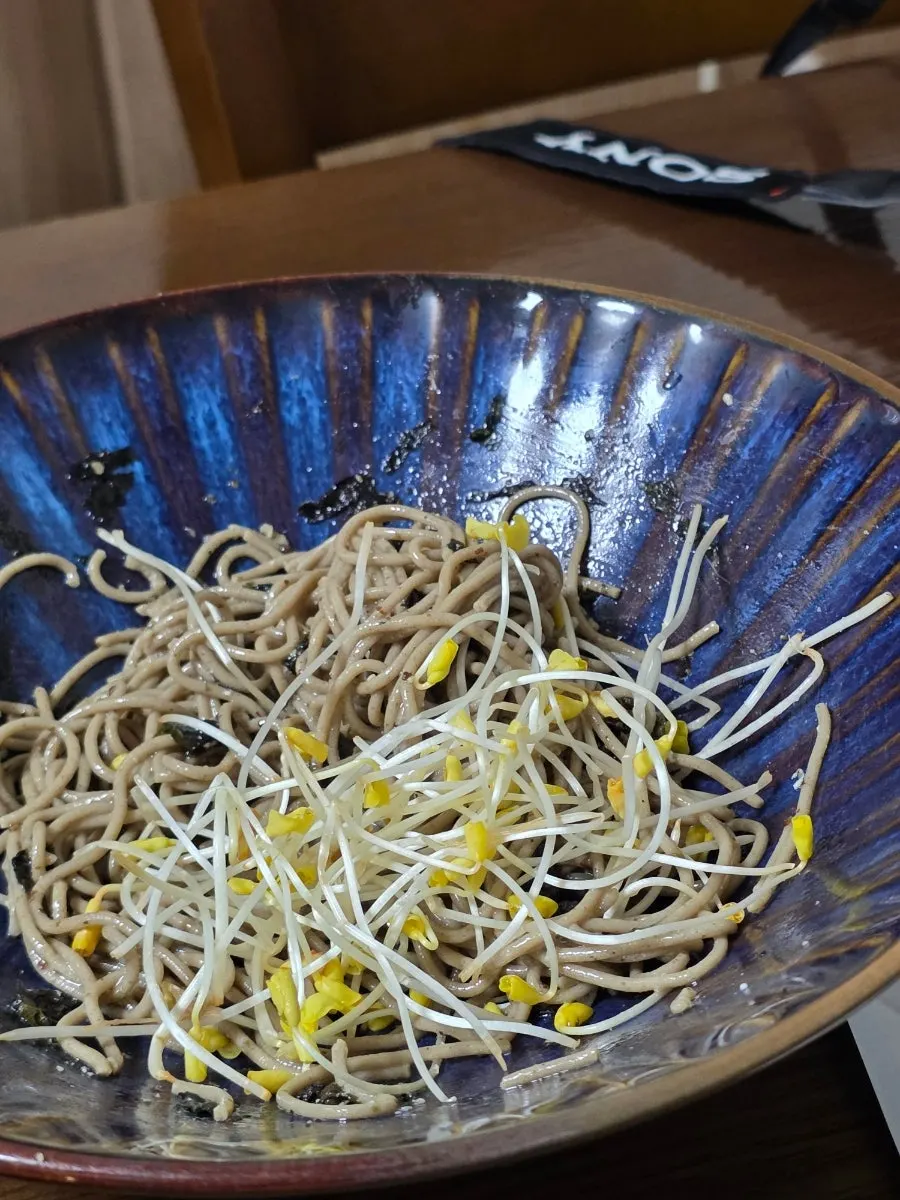 A bite combining buckwheat noodles and boiled pork