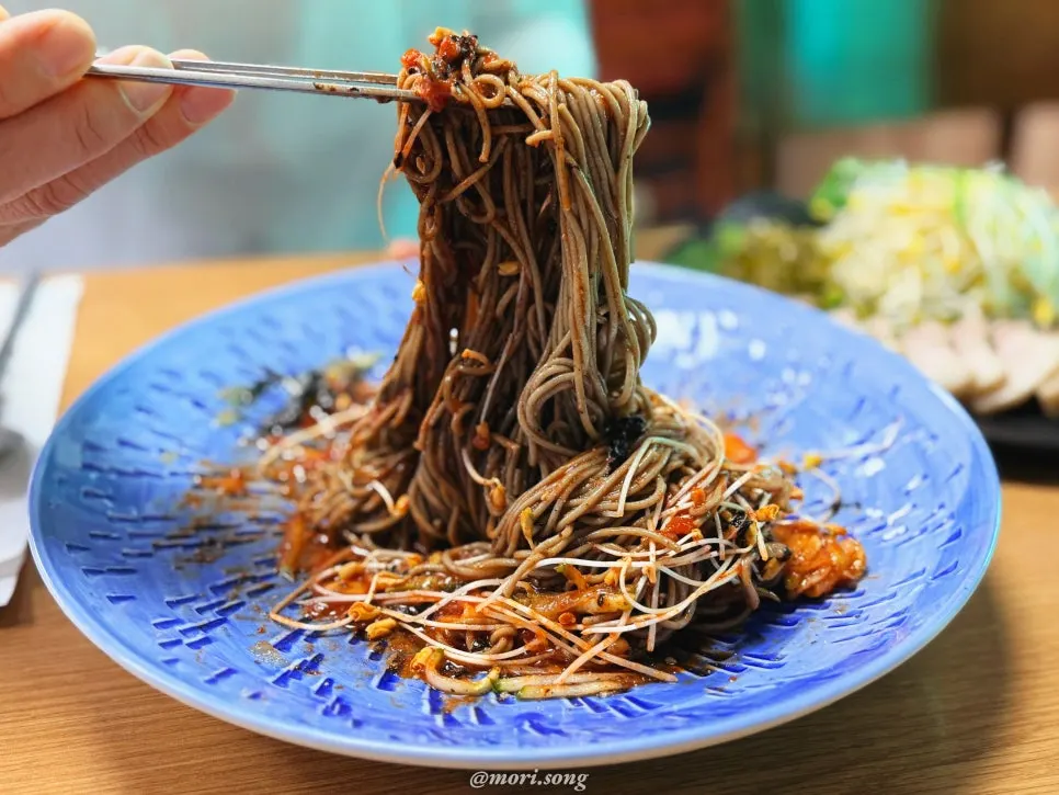 Close-up of memil bibim guksu noodles lightly coated in sauce