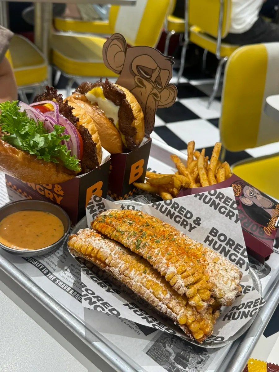 Two burgers, corn ribs, and seasoned fries set for two