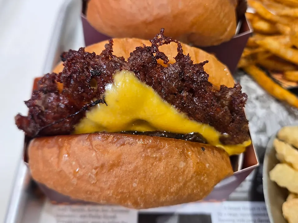 O.G Champion burger with two patties spilling out