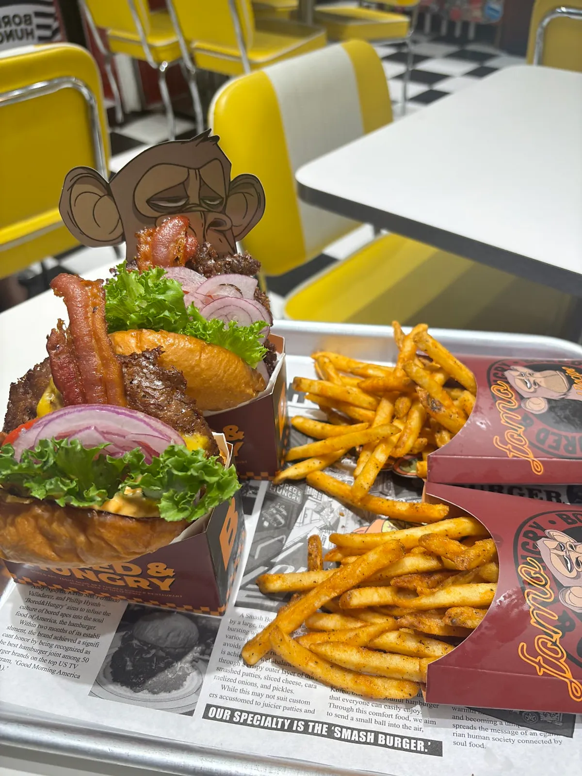 Bacon Deluxe burger and fries set laid out on the table