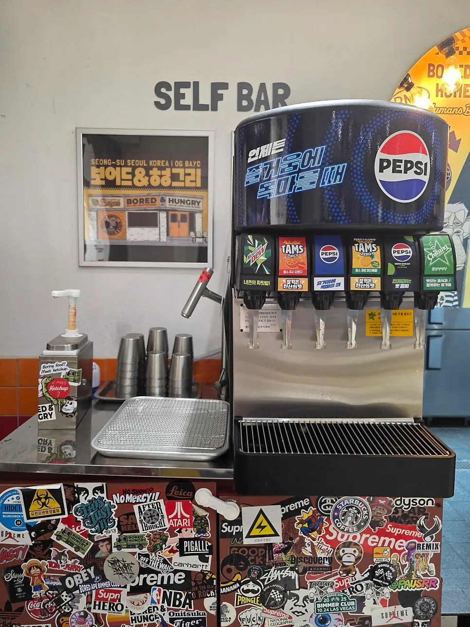 Self-serve soda bar with water and cups