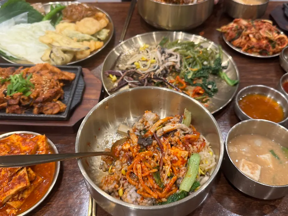 Full table spread with mackerel, pork, and namul side dishes