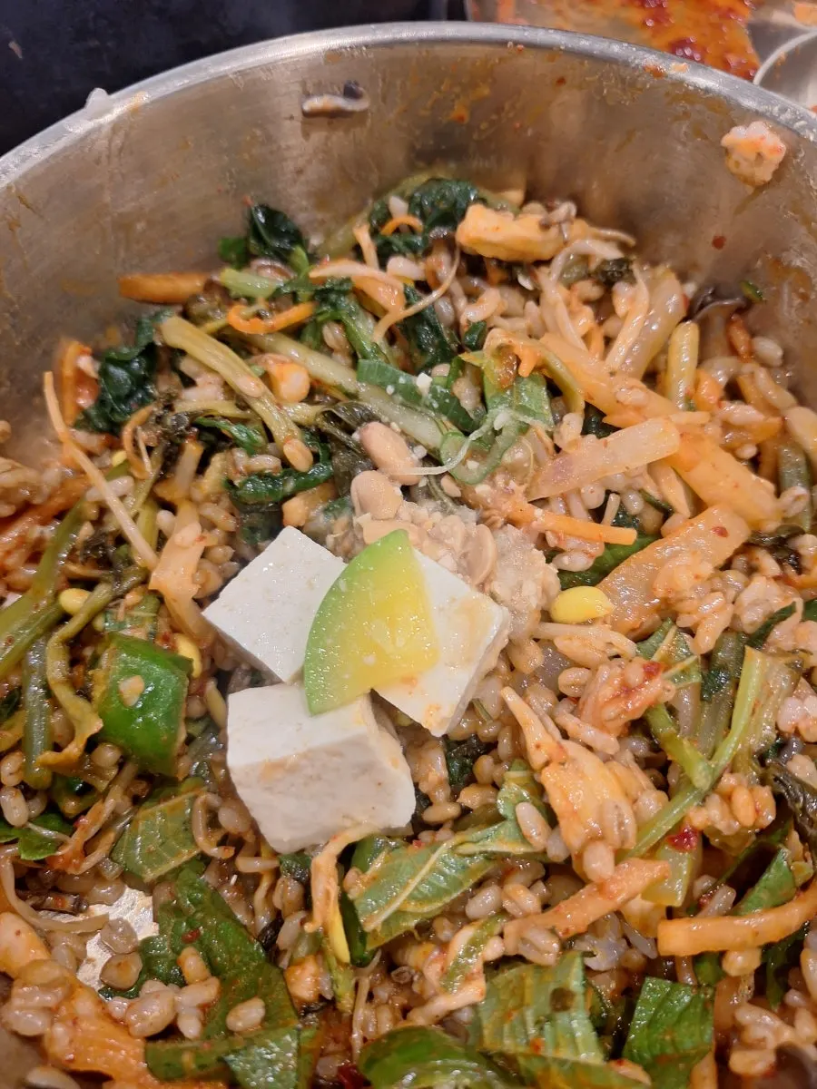 Namul topped by type over barley rice