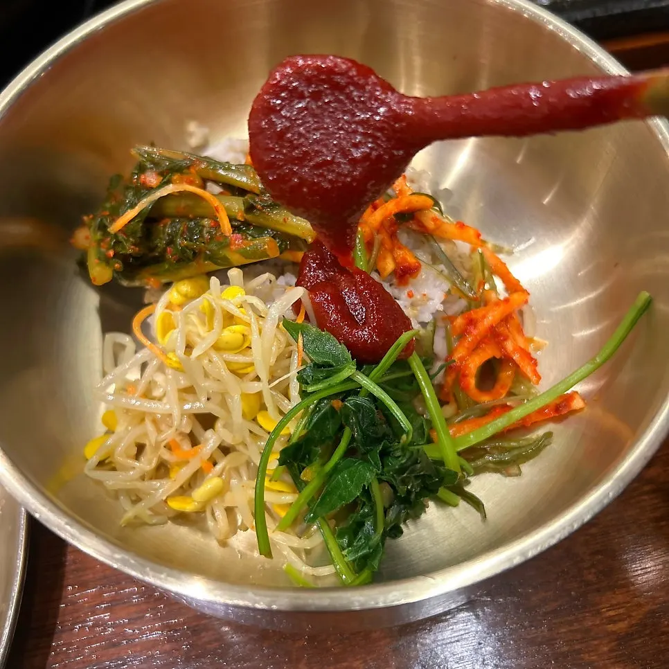Bibimbap of barley rice and namul in a brass bowl