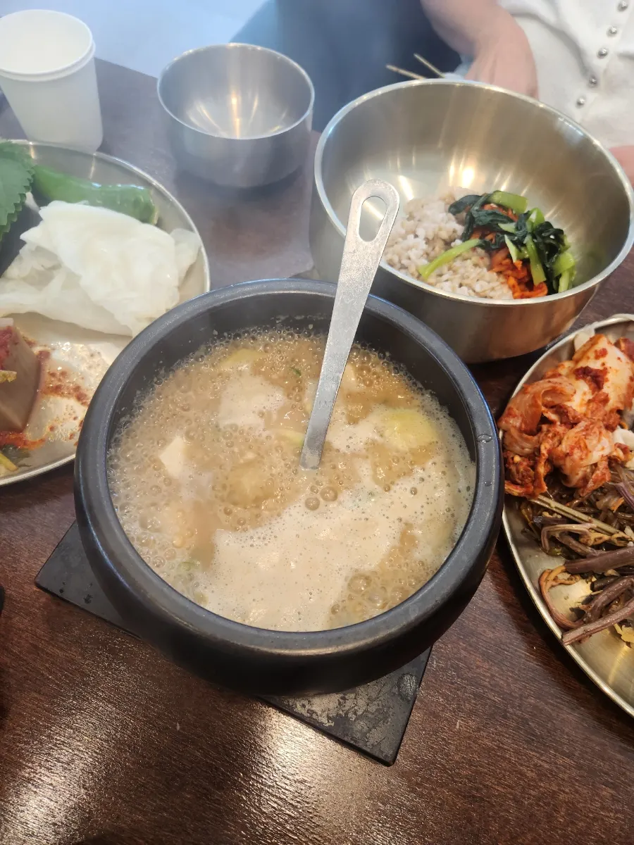 A spread of barley rice, side dishes, and a meat dish