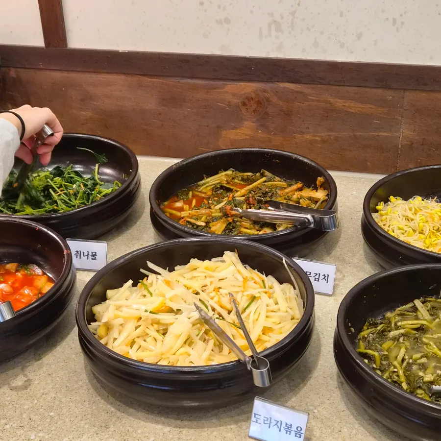 Namul side dishes plated and brought to the table
