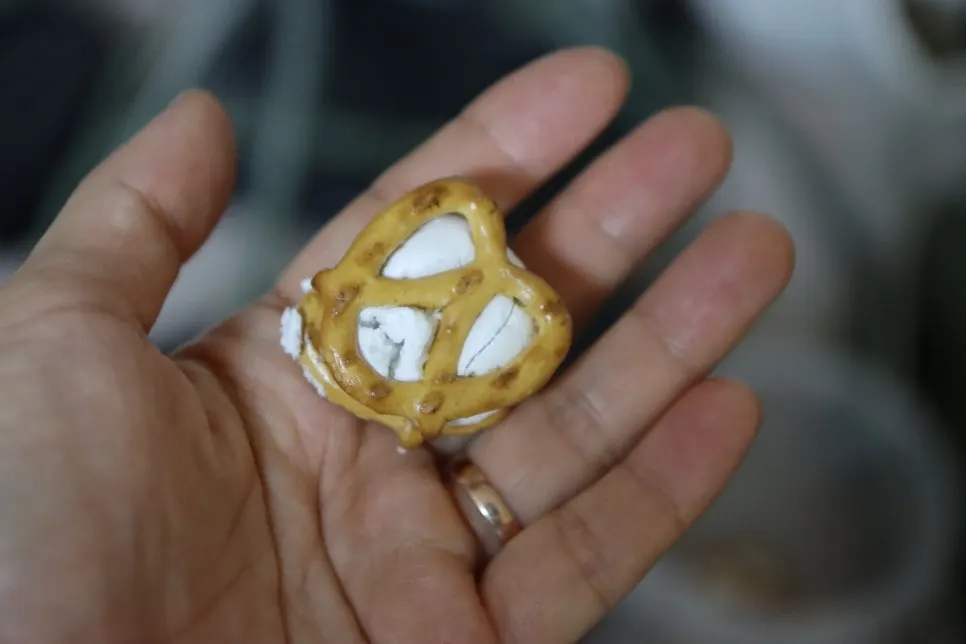 Pretzel meringue cookie held in a palm