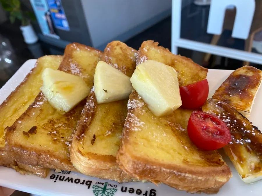 A plate of French toast with fruit