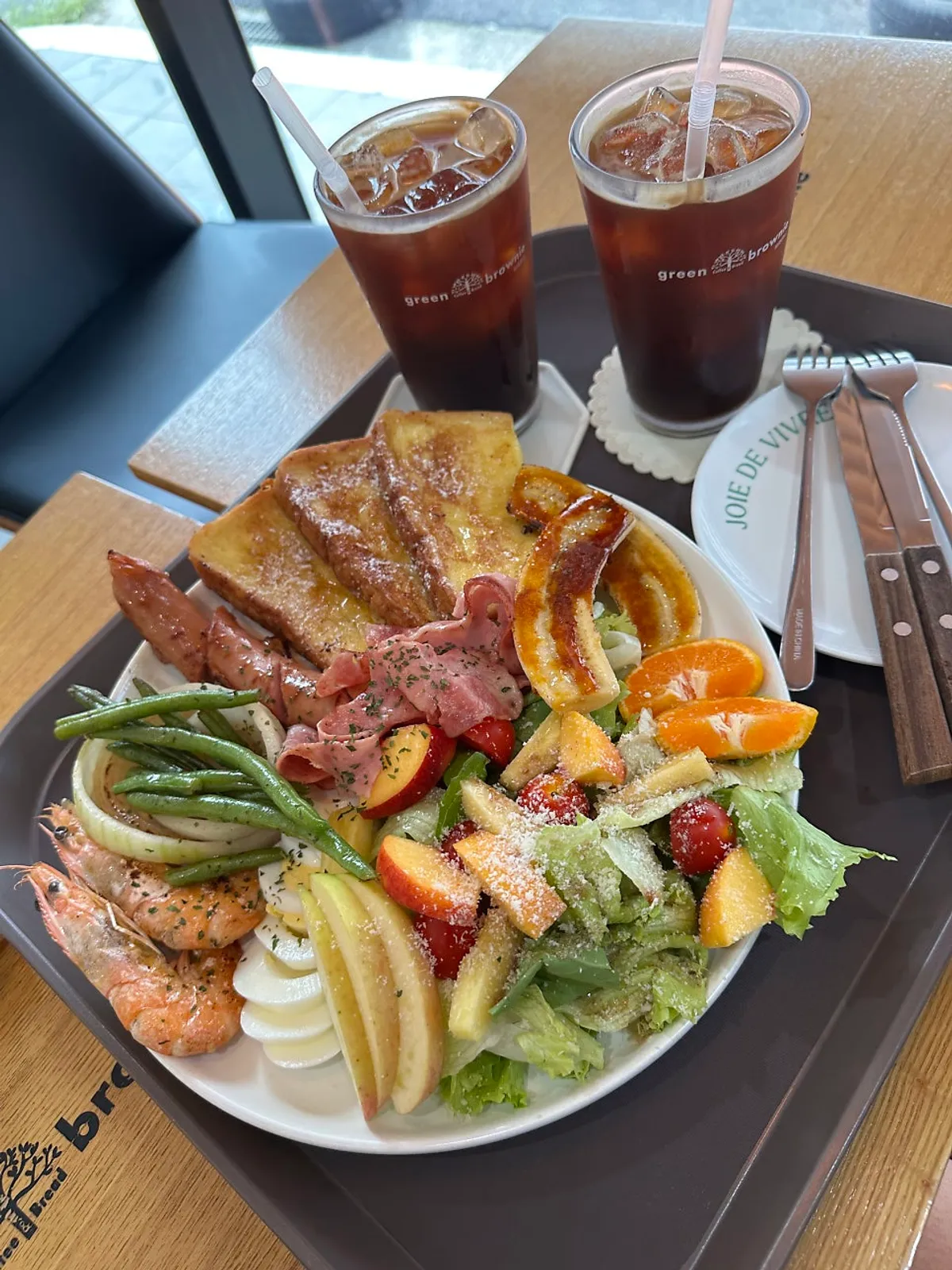 Mesa con el americano con hielo y el plato de brunch