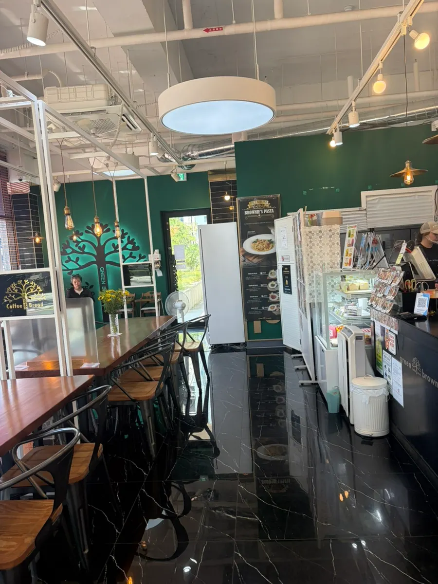 Café interior with sunlight streaming through floor-to-ceiling windows