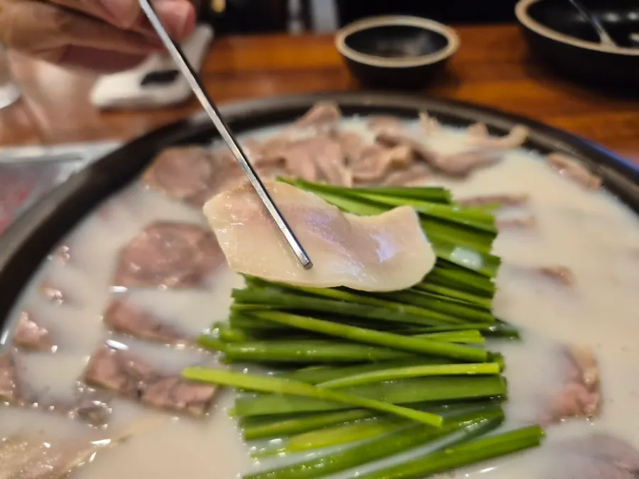 따뜻한 국물에 잠긴 모둠수육 한 점