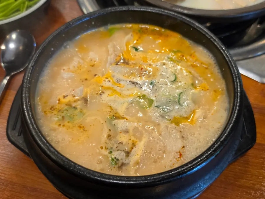 Pork jowl gukbap served bubbling in a stone bowl