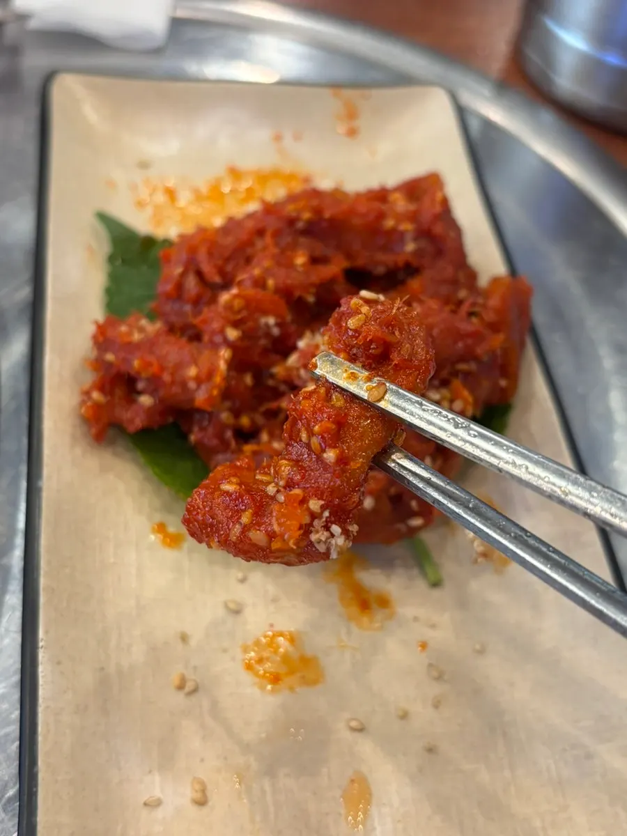 Chopsticks lifting a bite of pollack sashimi salad