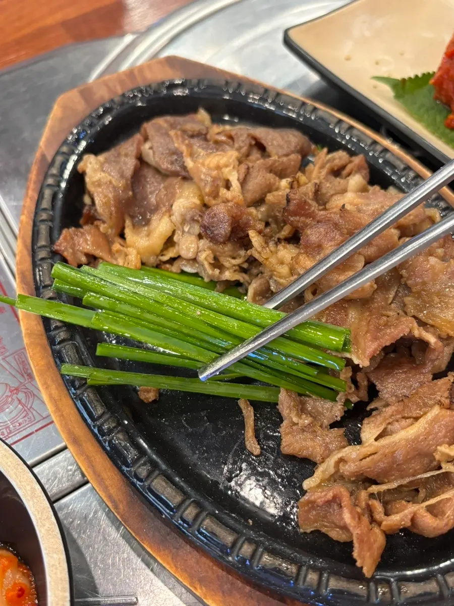 A piece of fire-grilled pork being picked up