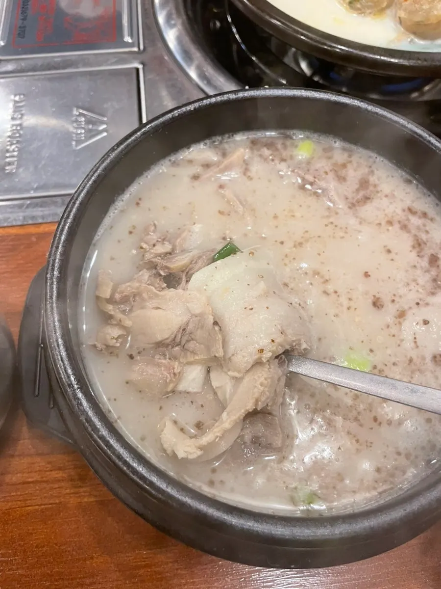 A bowl of bossam gukbap with milky broth