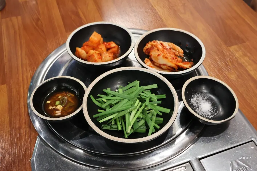 생 부추와 깍두기, 김치가 놓인 밑반찬 상차림