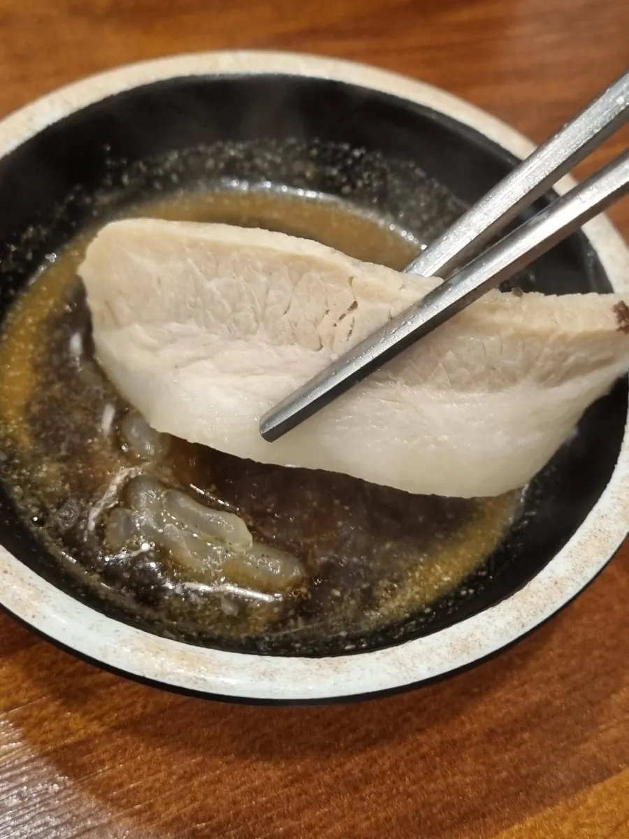 젓가락으로 집어 올린 항정수육 한 점