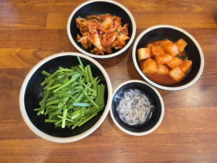Basic side dishes: kimchi, cubed radish kimchi, chives, and salted shrimp