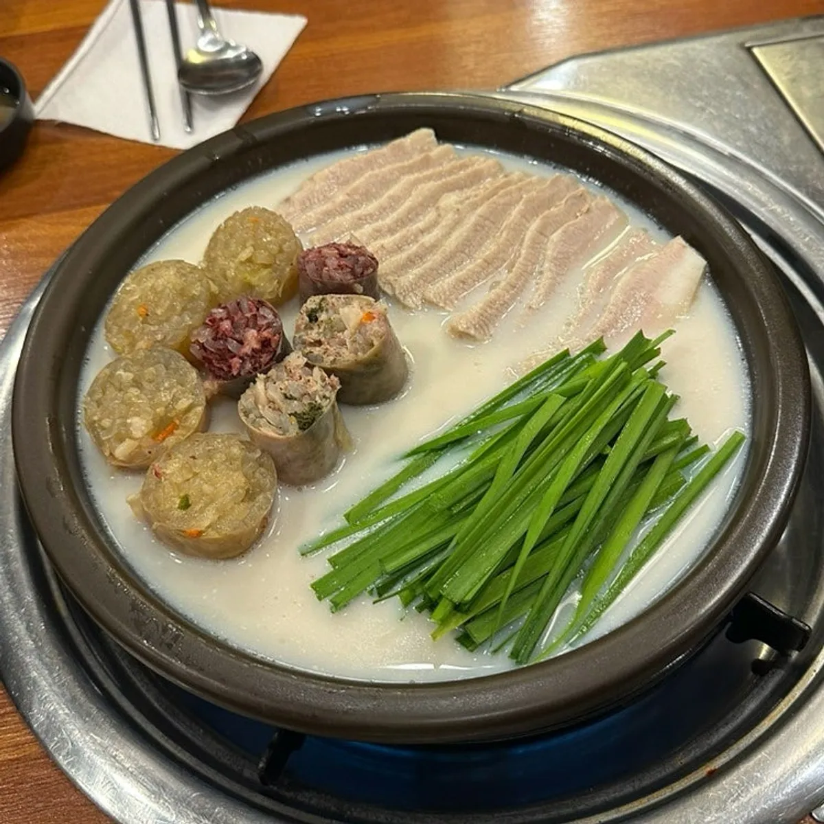 Pork neck suyuk and handmade blood sausage plate set over a burner