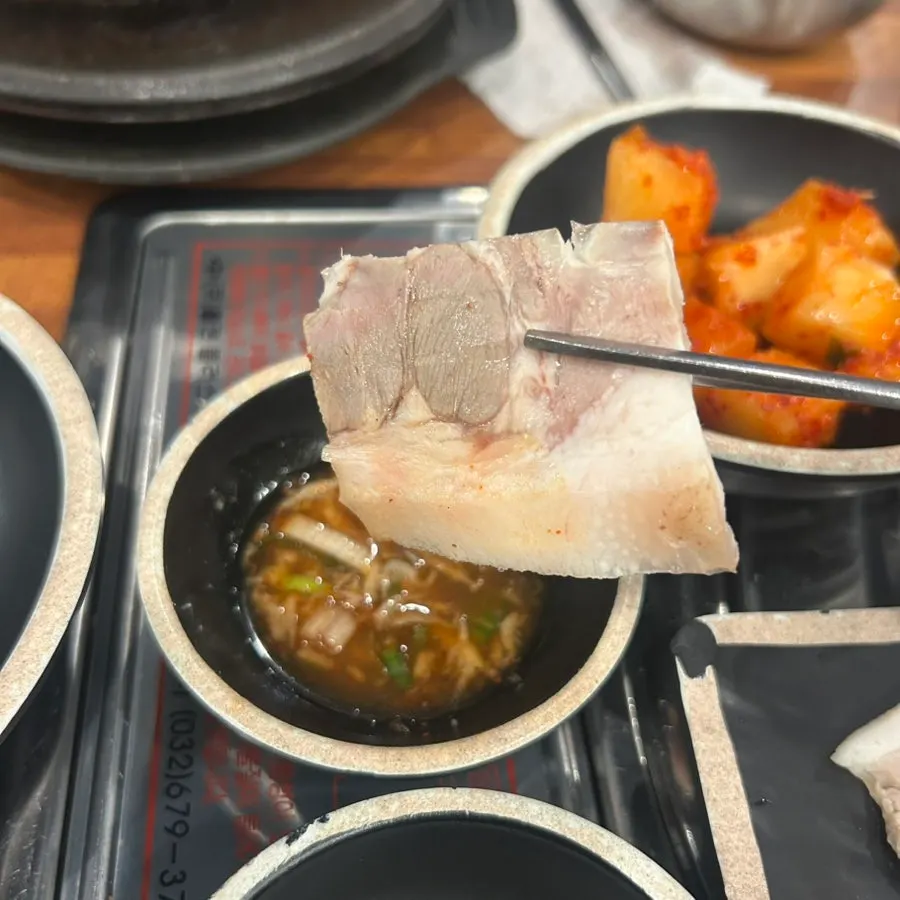 수육을 새우젓에 찍는 모습