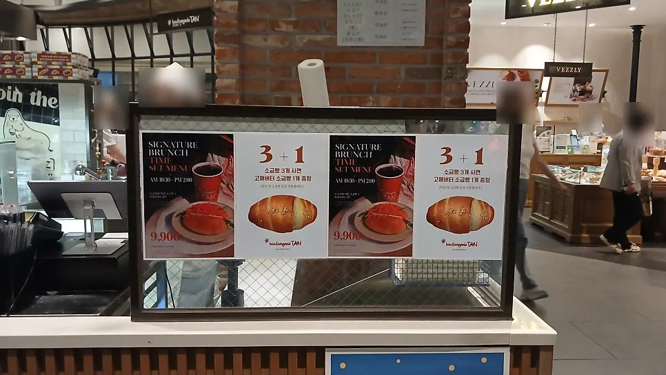 빵을 고르는 손님들이 보이는 블랑제리 탄 매장