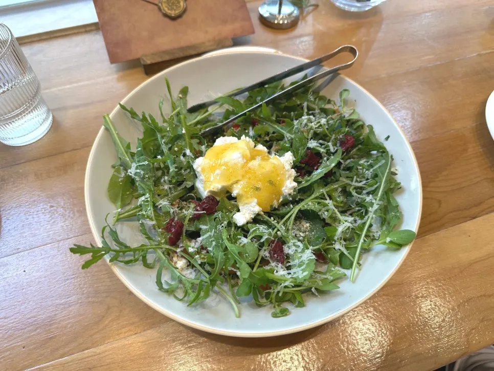 House salad topped with ricotta cheese and baby greens