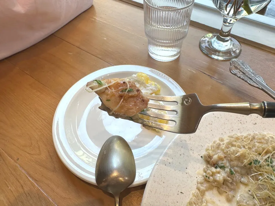 A spoonful of cream risotto topped with fried green onions