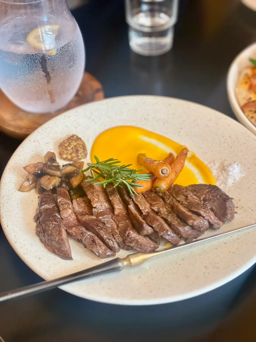 Flap steak served with pumpkin purée and roasted vegetables