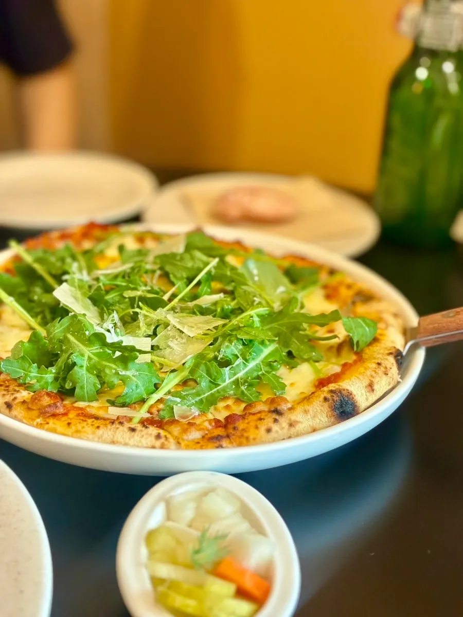 A slice of pizza topped with arugula