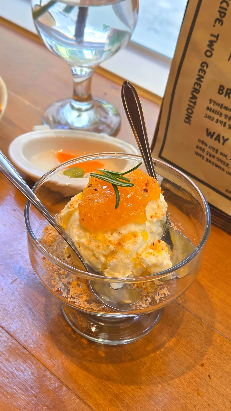 Vanilla ice cream dessert topped with orange jam and herbs