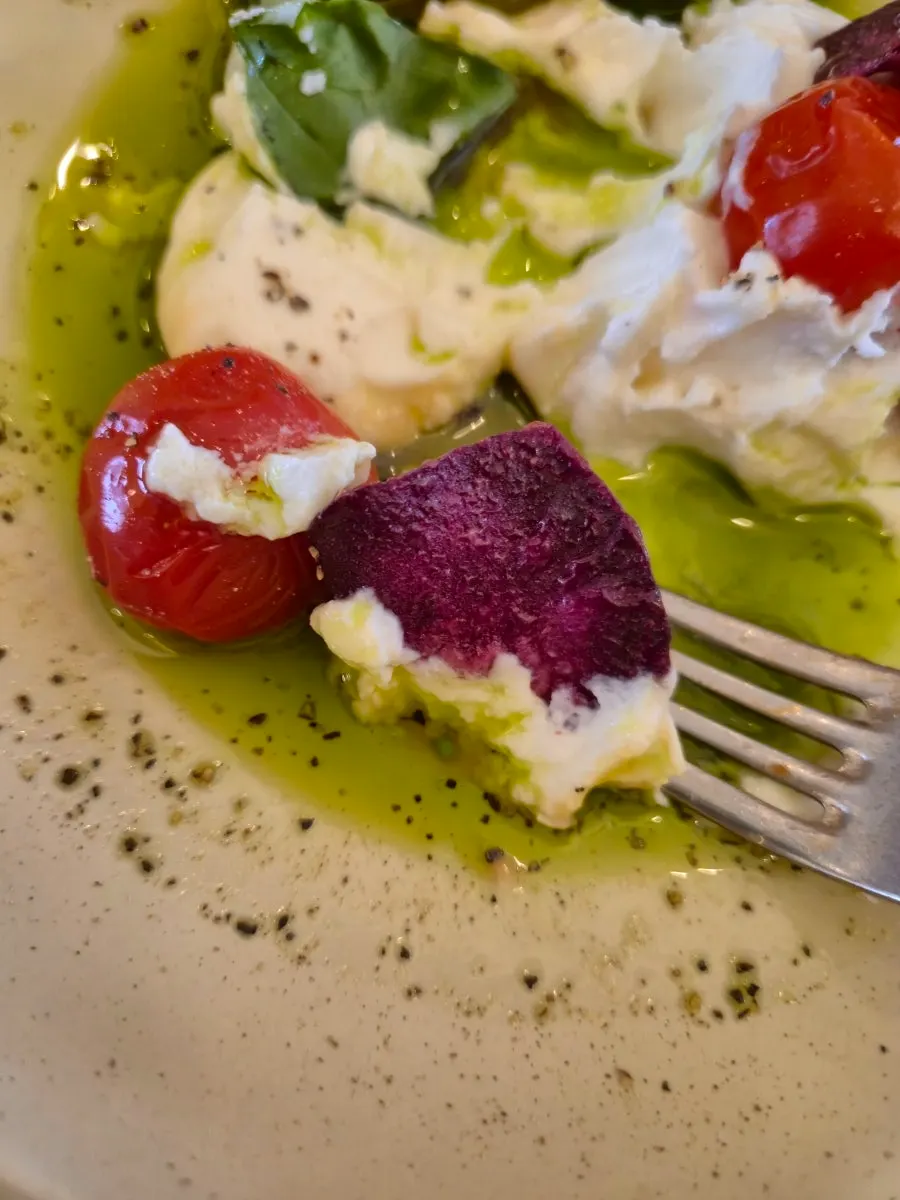 Close-up of Greek yogurt salad topped with tomato and basil
