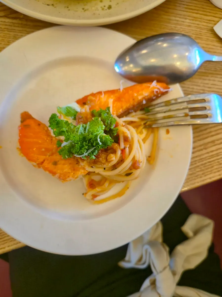 Dipping the added salmon steak into the sauce