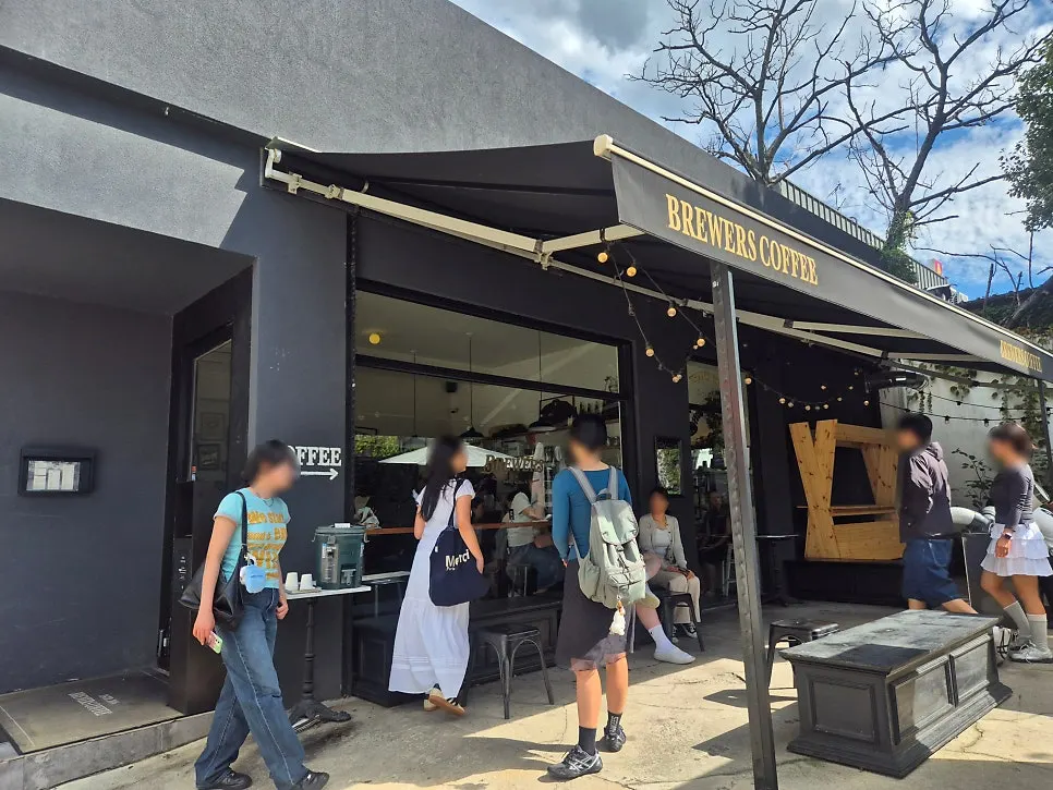 Exterior de Brewers Coffee Cheonan Sinbu Branch en tonos negro y blanco