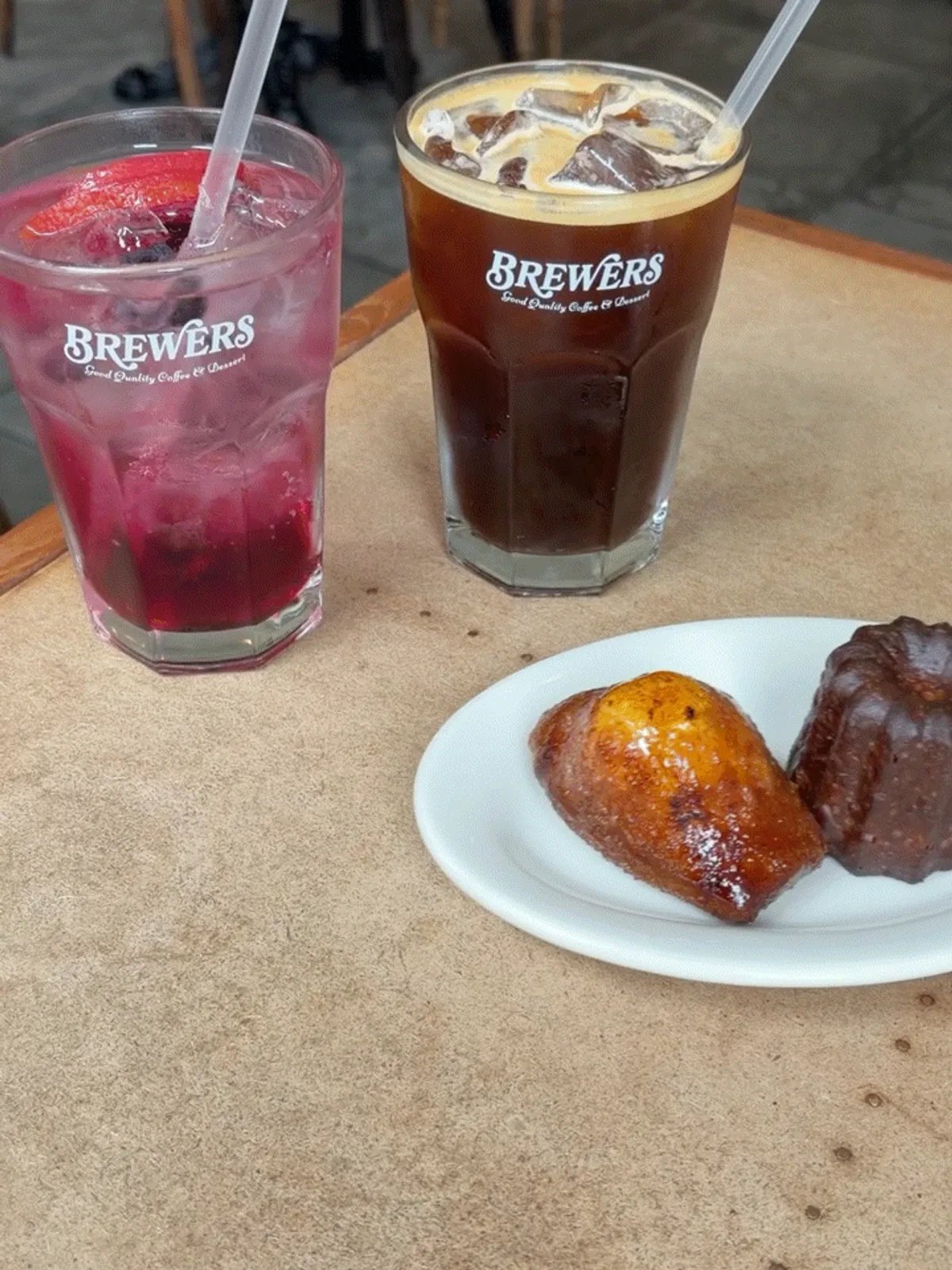 Iced americano and blueberry lemonade with baked goods on the table