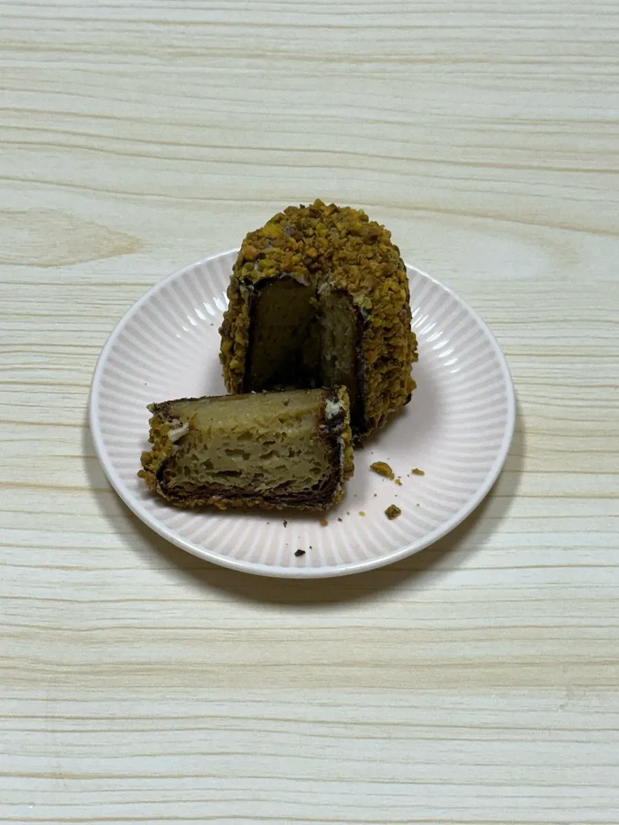 Pistachio canelé covered in pistachio pieces