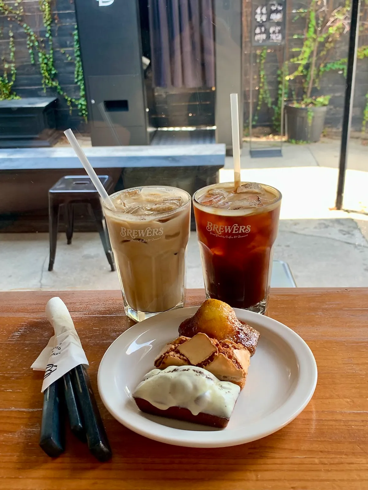 Table with iced americano and three baked treats