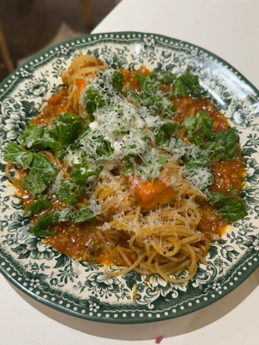 Whole salmon steak on top of ragu-based tomato pasta