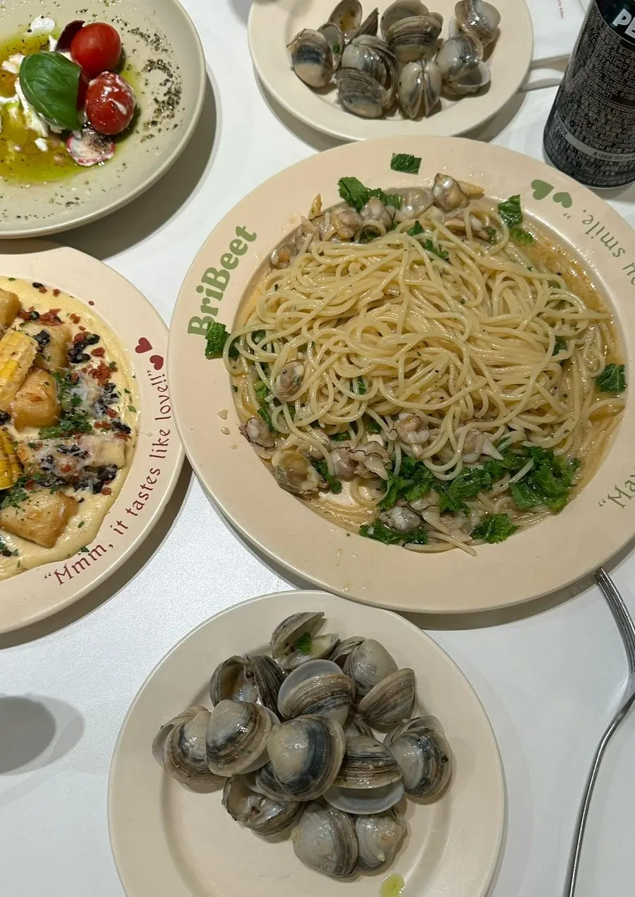 A plate of vongole pasta topped with arugula