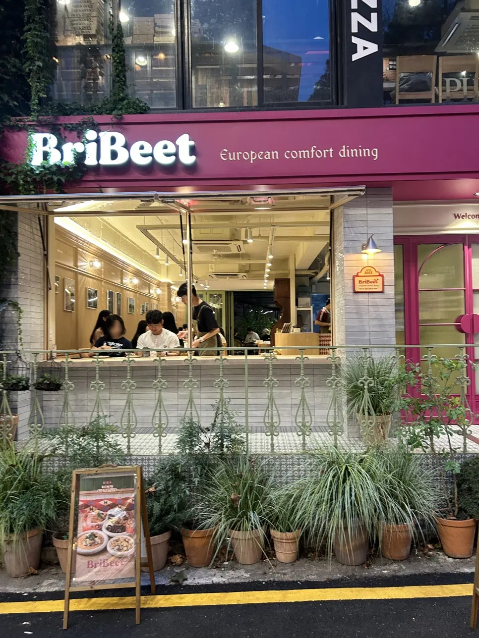 핑크색 외관과 식물이 놓인 브리비트 강남역 입구